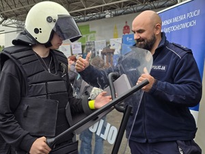 zdjęcie przedstawia policjanta i uczestników festynu przy stoisku profilaktycznym