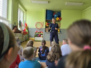 zdjęcie przedstawia policjantkę rozmawiającą z dziećmi