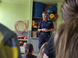zdjęcie przedstawia policjantkę rozmawiającą z dziećmi