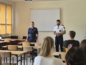 zdjęcie przedstawia policjantkę i strażnika miejskiego rozmawiających z uczniami liceum