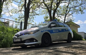 zdjęcie przedstawia radiowóz z włączonymi sygnałami świetlnymi