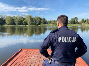 zdjęcie przedstawia dzielnicowego kontrolującego zbiornik wodny