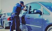 zdjęcie przedstawia policjanta zerkającego do samochodu