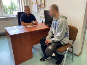 zdjęcie przedstawia policjanta i podejrzanego mężczyznę