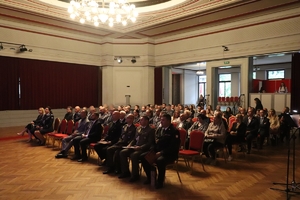zdjęcie przedstawia siedzących na sali policjantów i gości
