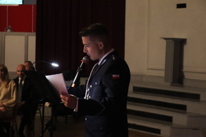 zdjęcie przedstawia policjanta czytającego tekst