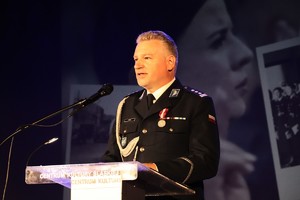 zdjęcie przedstawia komendanta przemawiającego do mikrofonu