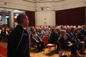 zdjęcie przedstawia siedzących na sali policjantów i gości