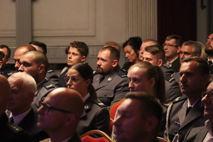 zdjęcie przedstawia siedzących na sali policjantów i gości