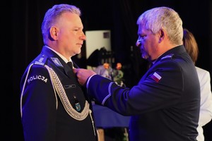 zdjęcie przedstawia komendanta wręczającego odznaczenie
