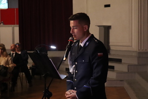 zdjęcie przedstawia policjanta mówiącego do mikrofonu