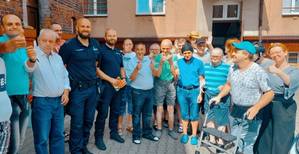 zdjęcie przedstawia dzielnicowego z podopiecznymi domu pomocy społecznej