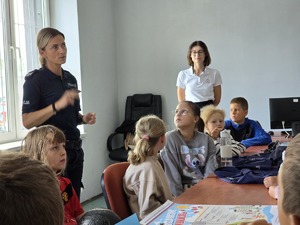 zdjęcie przedstawia policjantkę rozmawiającą z dziećmi
