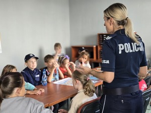 zdjęcie przedstawia policjantkę rozmawiającą z dziećmi