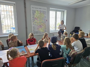 zdjęcie przedstawia pracowniczkę sanepidu rozmawiającą z dziećmi