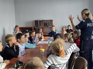 zdjęcie przedstawia policjantkę rozmawiającą z dziećmi