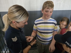 zdjęcie przedstawia policjantkę i dzieci na prelekcji w komendzie