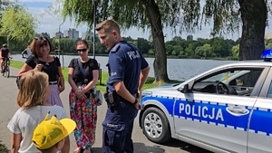 zdjęcie przedstawia policjanta rozdającego bilety na basen