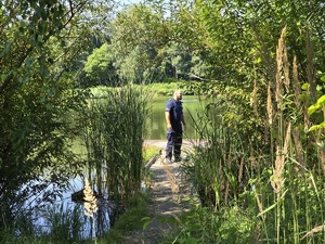 zdjęcie przedstawia policjanta kontrolującego zbiornik wodny