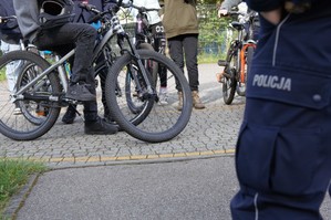 zdjęcie przedstawia policjanta i młodzież na rowerach