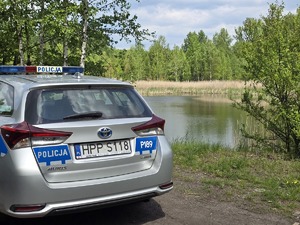zdjęcie przedstawia radiowóz na tle stawu