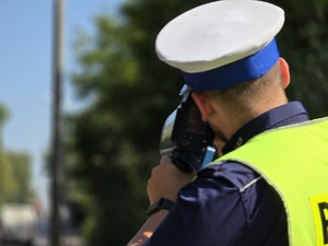 zdjęcie przedstawia policjanta mierzącego prędkość
