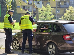 zdjęcie przedstawia policjantów kontrolujących samochód