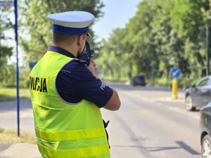 zdjęcie przedstawia policjanta mierzącego prędkość
