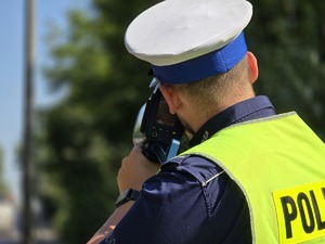 zdjęcie przedstawia policjanta mierzącego prędkość