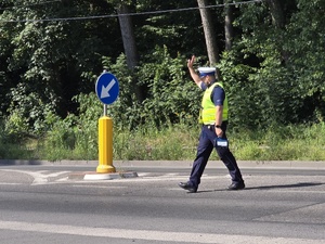 zdjęcie przedstawia policjanta zatrzymującego ruch
