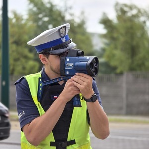 zdjęcie przedstawia policjanta mierzącego prędkość
