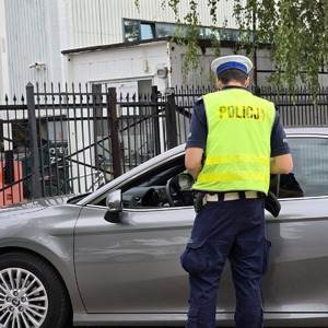 zdjęcie przedstawia policjanta podczas kontroli drogowej