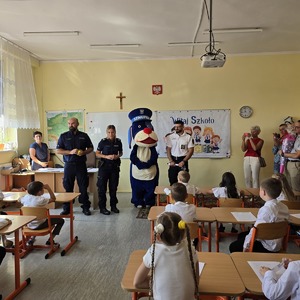 zdjęcie przedstawia: policjantów, strażnika miejskiego i psa sznupka na rozpoczęciu roku szkolnego