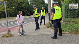 zdjęcie przedstawia: policjantów ruchu drogowego przy przejściu dla pieszych rozmawiających z uczniami