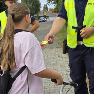zdjęcie przedstawia: policjantów ruchu drogowego wręczającego odblaski