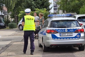zdjęcie przedstawia: policjantów ruchu drogowego przy radiowozie