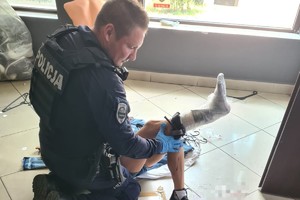 zdjęcie przedstawia policjanta udzielającego pierwszej pomocy