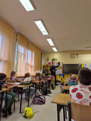 zdjęcie przedstawia: policjanta rozmawiającego z uczniami