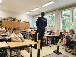 zdjęcie przedstawia: policjanta rozmawiającego z uczniami