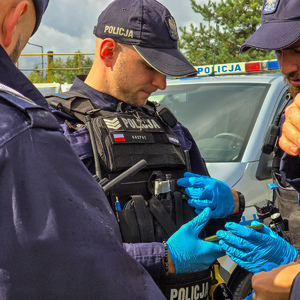 zdjęcie przedstawia: policjanta w rękawiczkach jednorazowych