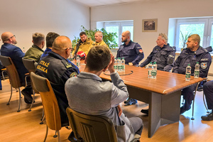 zdjęcie przedstawia: policjantów i strażaków podczas omawiania rezultatów ćwiczeń