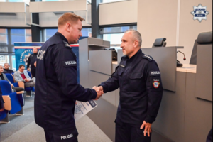 zdjęcie przedstawia: komendanta ściskającego dłoń policjantowi