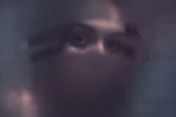 zdjęcie przedstawia kobietę za zaparowaną szybą