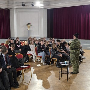 zdjęcie przedstawia funkcjonariuszkę straży granicznej rozmawiającą z młodzieżą