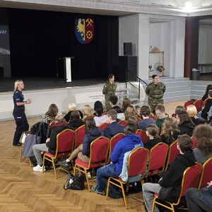 zdjęcie przedstawia policjantkę i funkcjonariuszkę straży granicznej rozmawiającą z młodzieżą