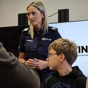 zdjęcie przedstawia policjantkę rozmawiającą z uczniami