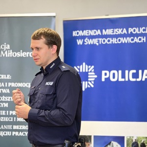 zdjęcie przedstawia policjanta rozmawiającego z uczniami