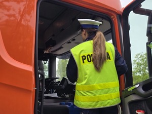 zdjęcie przedstawia policjantkę podczas kontroli samochodu ciężarowego