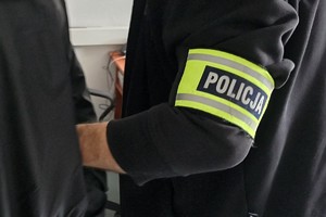 zdjęcie przedstawia policjanta trzymającego mężczyznę