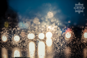 zdjęcie przedstawia odbite światła reflektorów w szybie